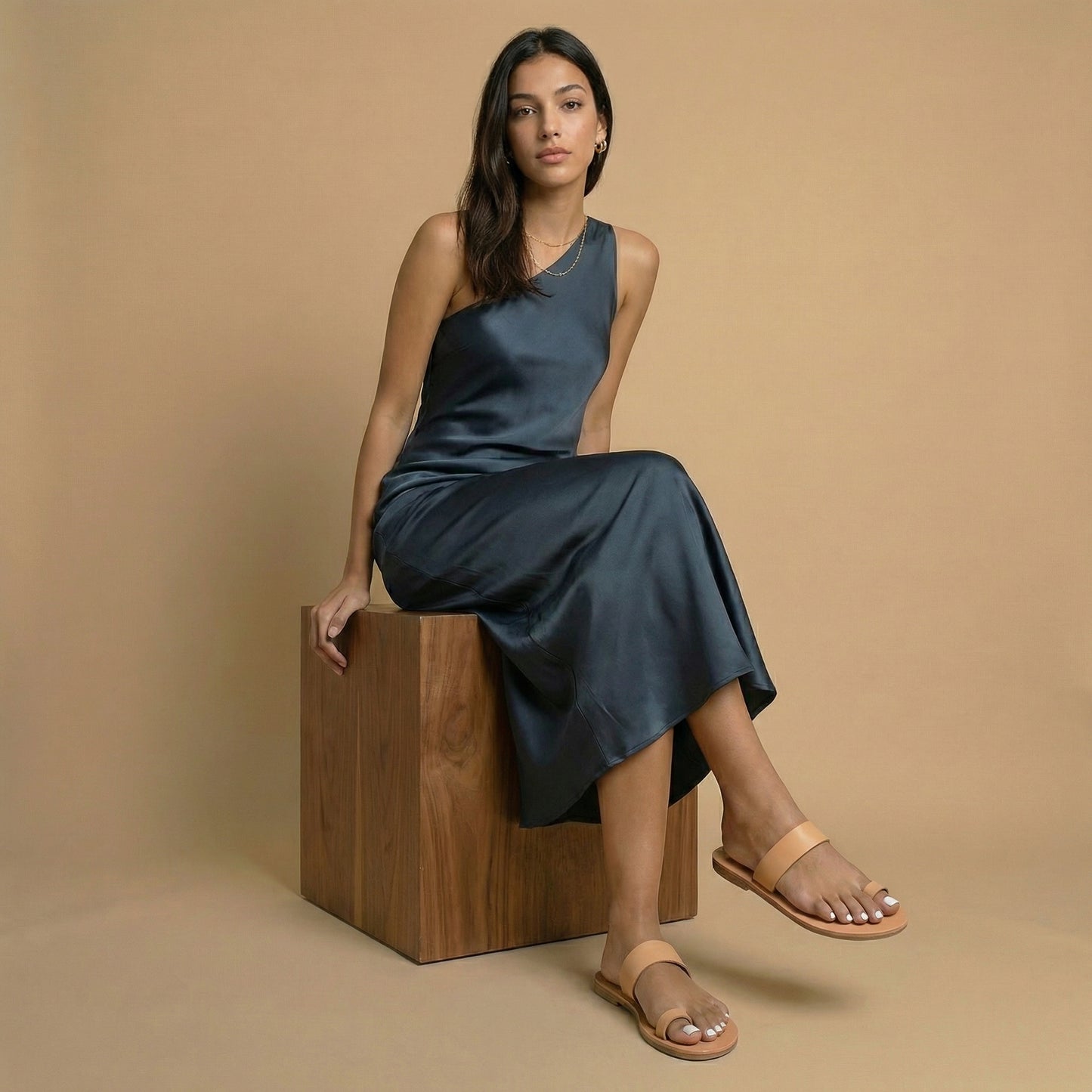 Woman wearing a pair of elegant flat sandals in camel against a white background. Part of our flat footwear for womens collection.