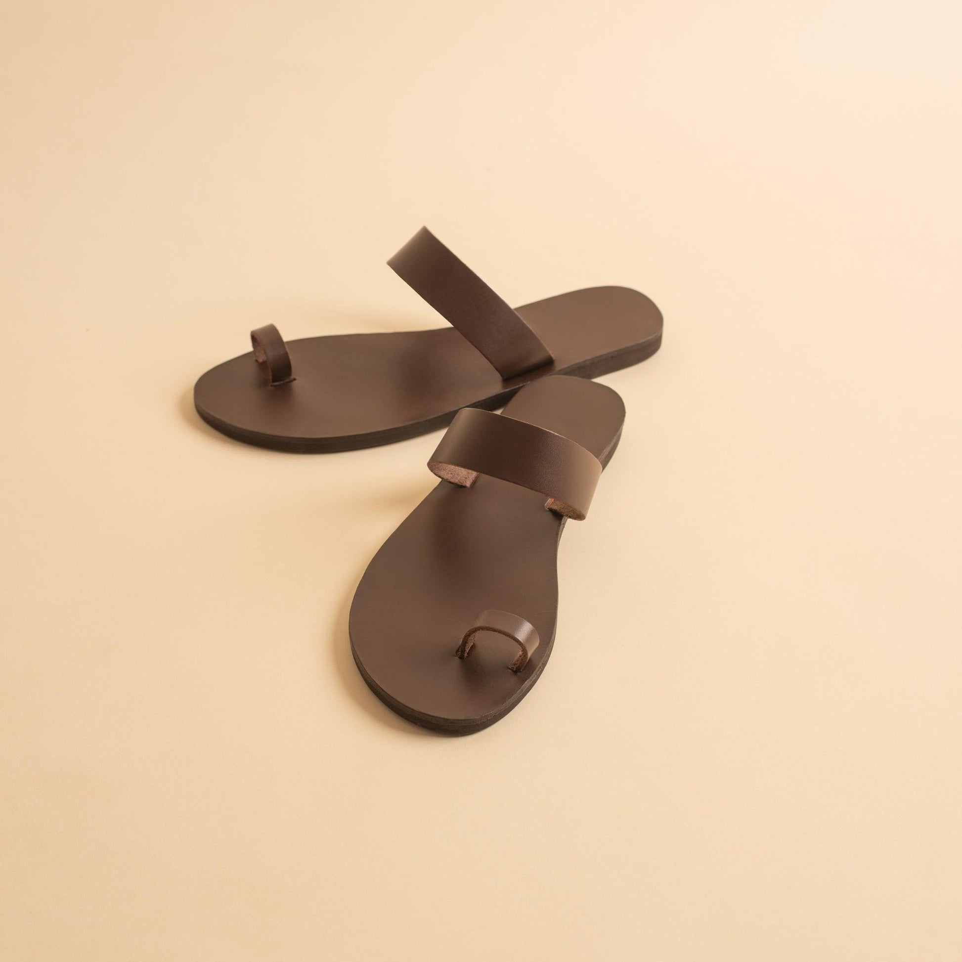 Astara sandals women's against a beige background. They are flat sandals brown.