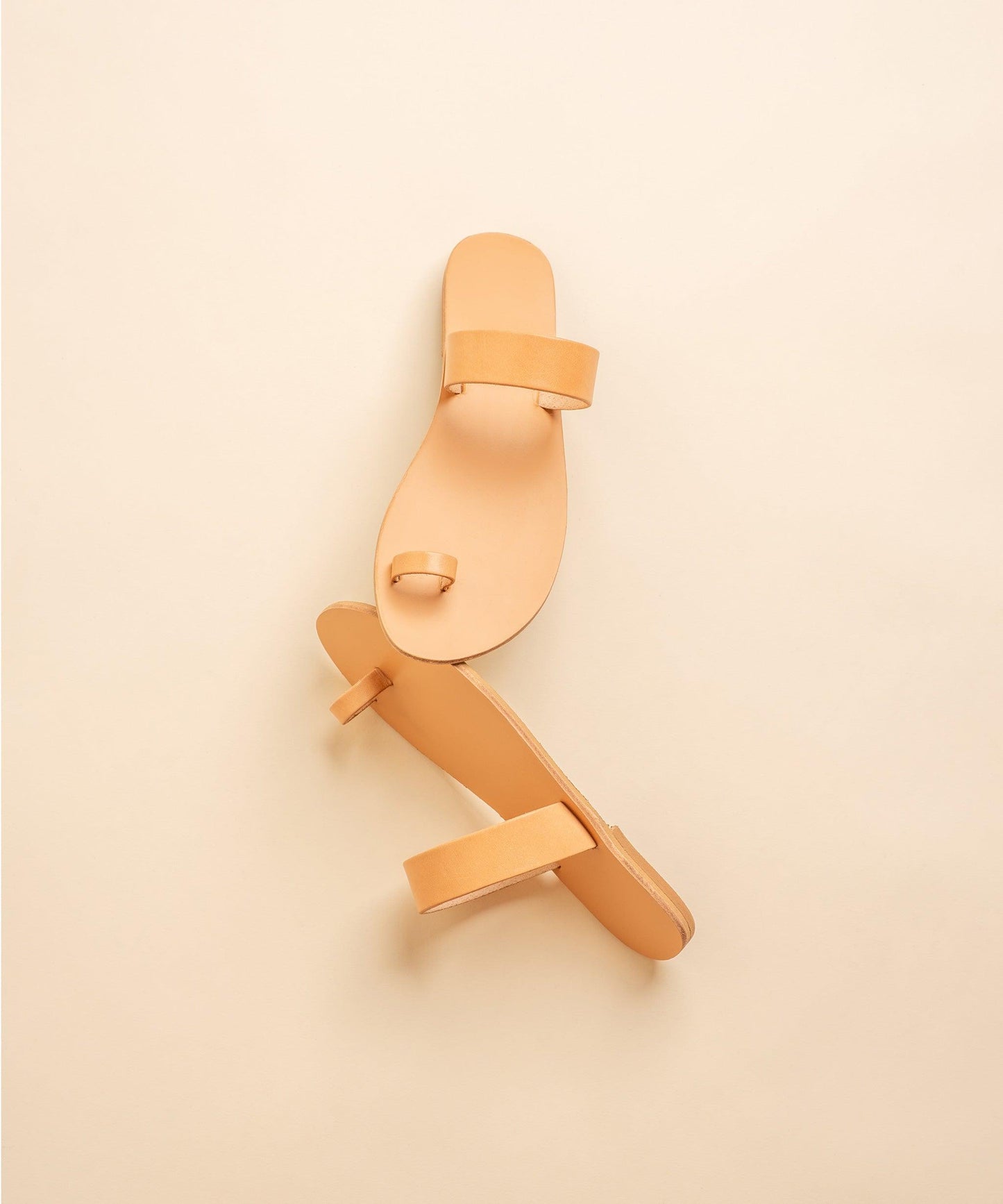 Elegant flat sandals in camel against a beige background. Part of our flat footwear for womens collection.