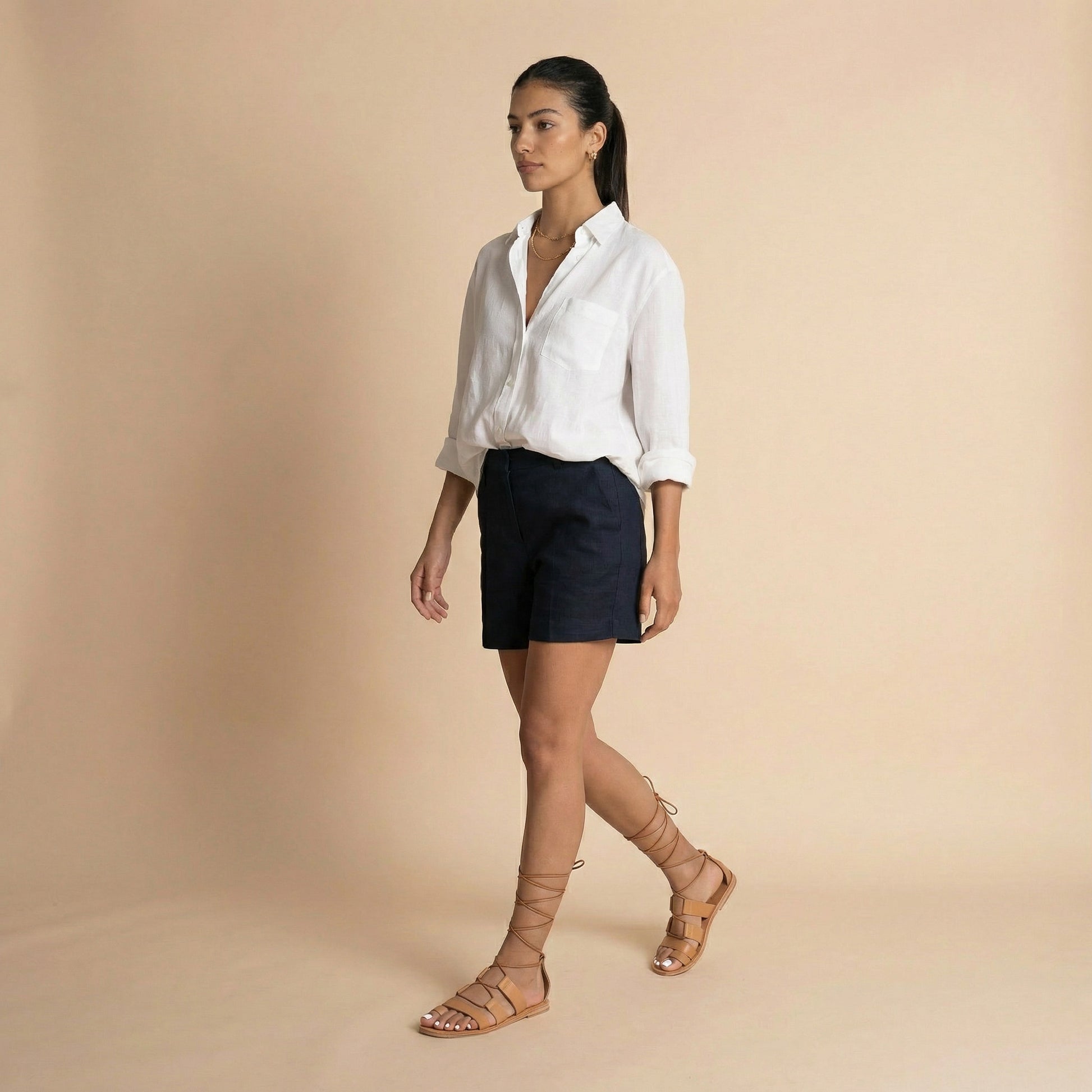 Woman wearing a pair of tan Athanasia flat sandals strappy against a white background. They are women's lace up flats.