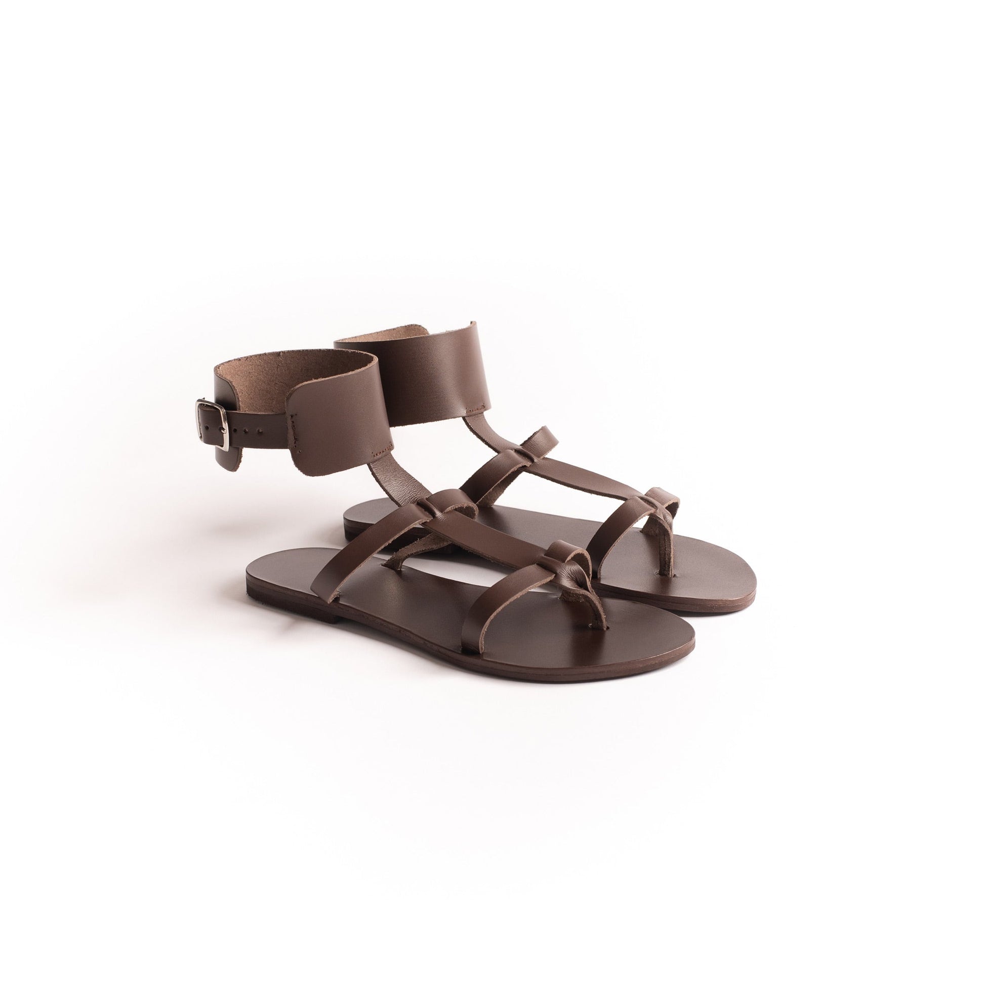 Athena brown flats against a white background. They are flat sandals with buckle.