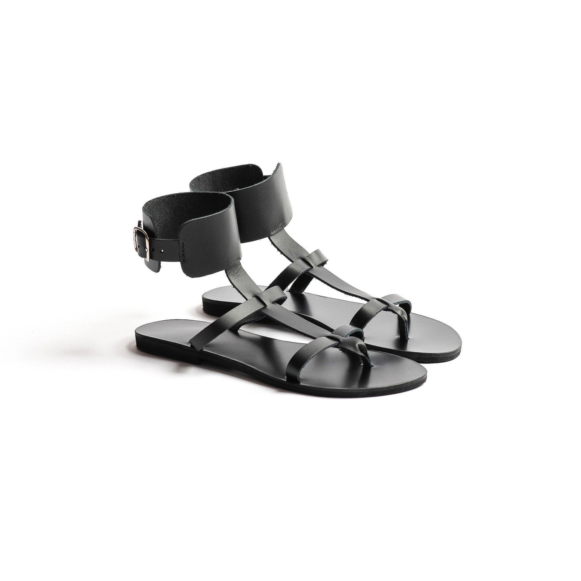 Athena black leather sandals against a white background. They are black flat gladiator sandals.