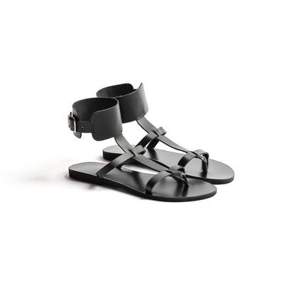 Athena black leather sandals against a white background. They are black flat gladiator sandals.