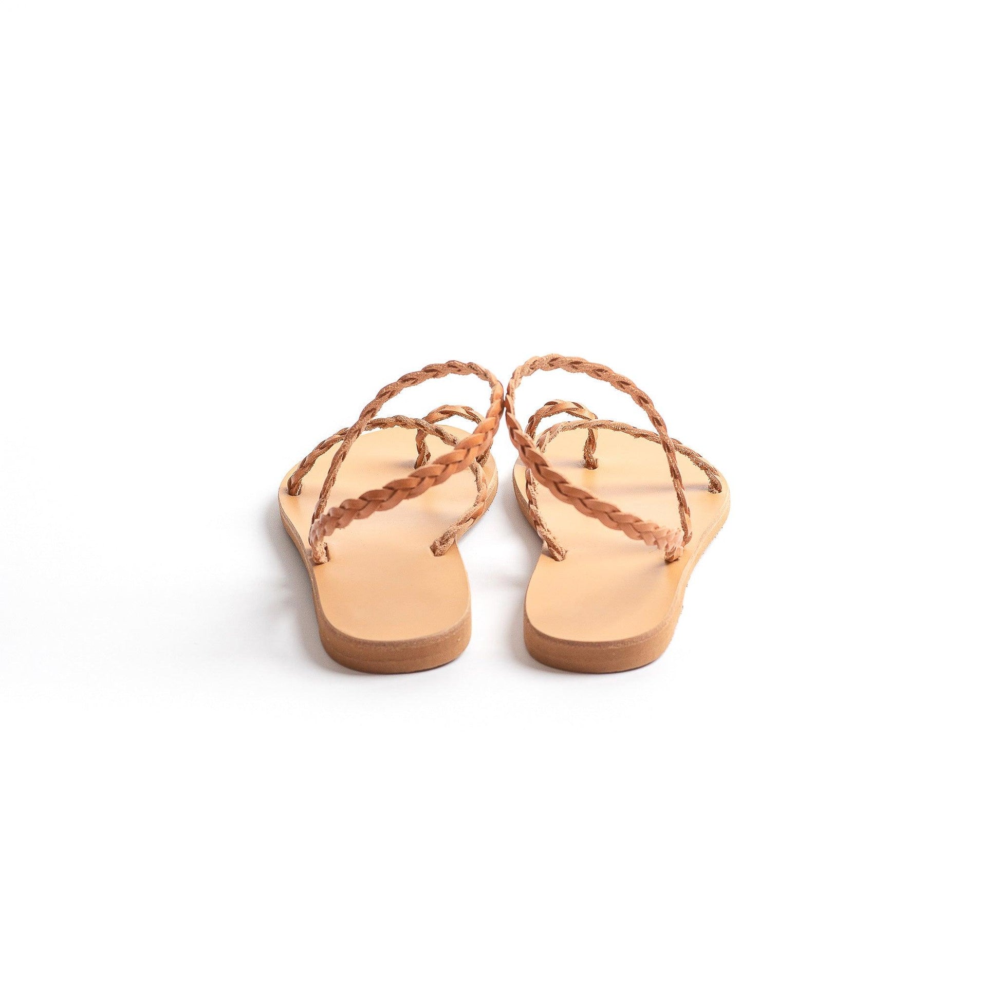 Back view of a pair of tan leather sandals flat for women against a white background. They are flat sandals with back strap. These flat sandals tan are the perfect flat sandals to wear with dresses.