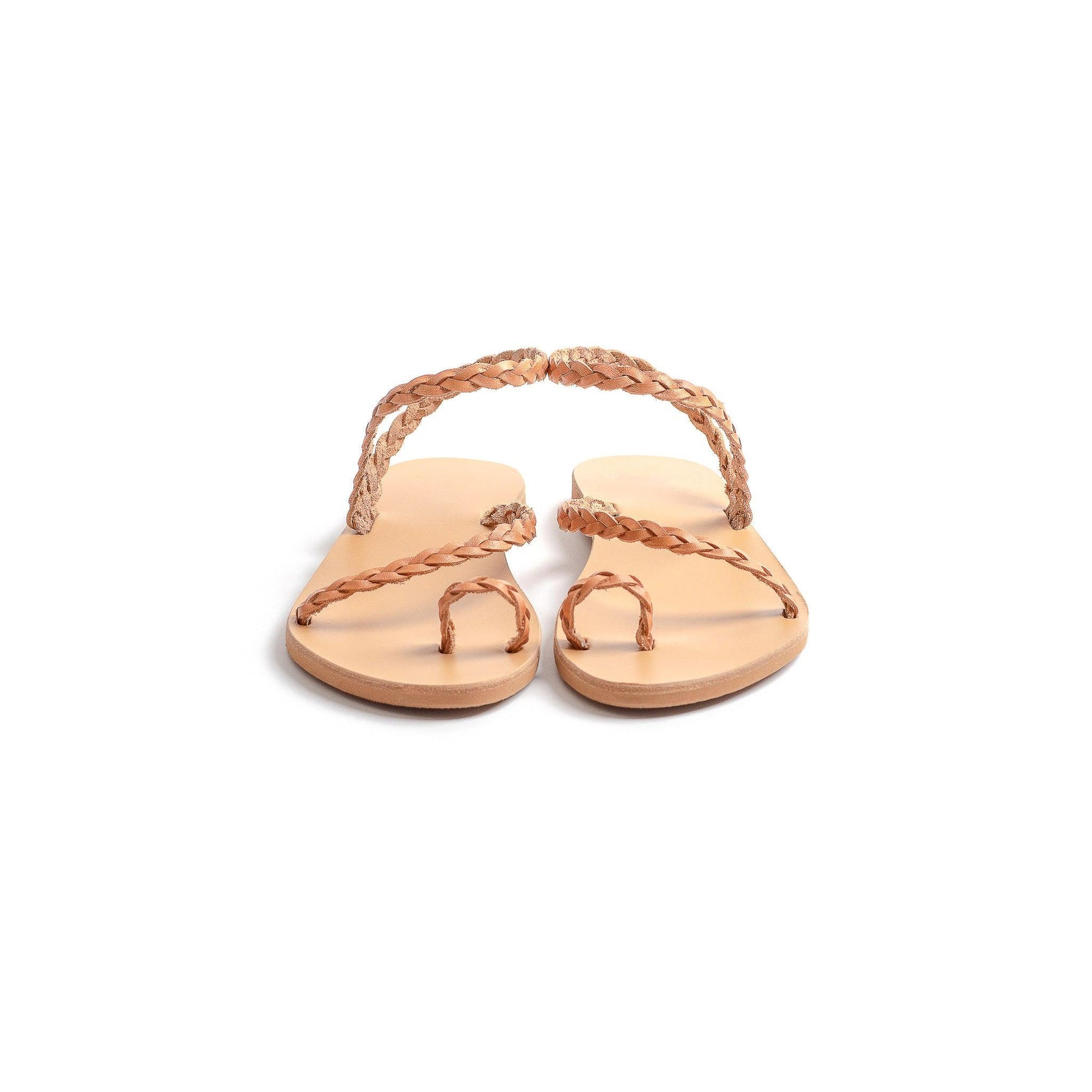 Front view of a pair of tan leather sandals flat for women against a white background. They are flat sandals with back strap.