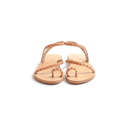 Front view of a pair of tan leather sandals flat for women against a white background. They are flat sandals with back strap.