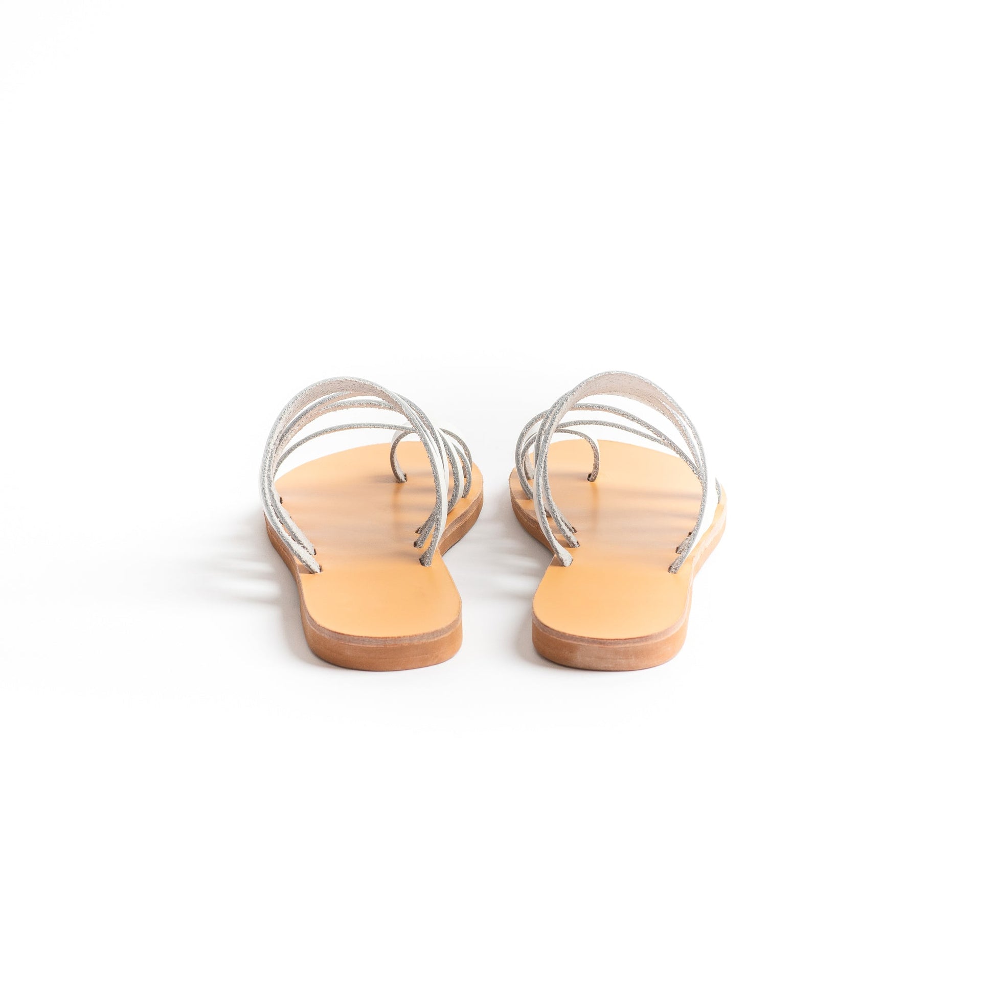 Back view of Harmonia white slide sandals against a white background. These white leather sandals are white flats for women.