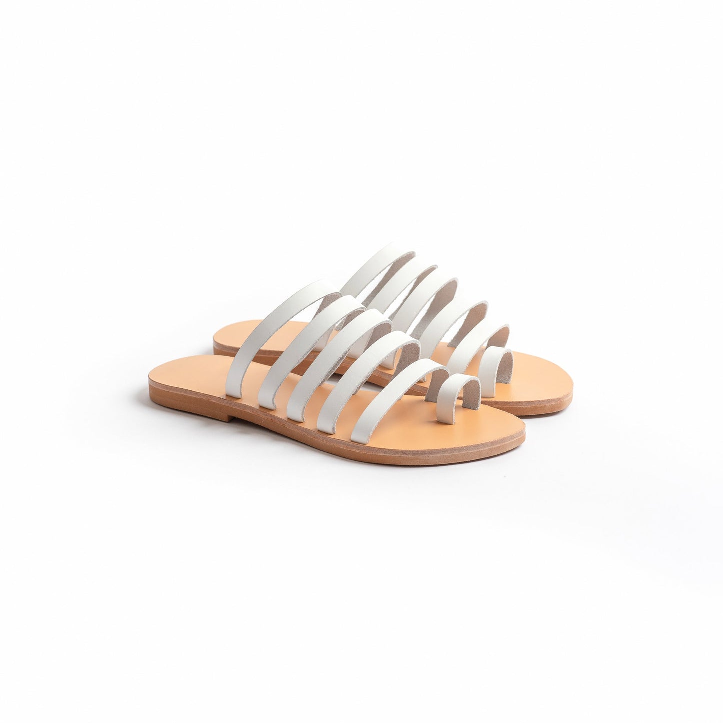 Harmonia white slide sandals against a white background. These white leather sandals are white flats for women.