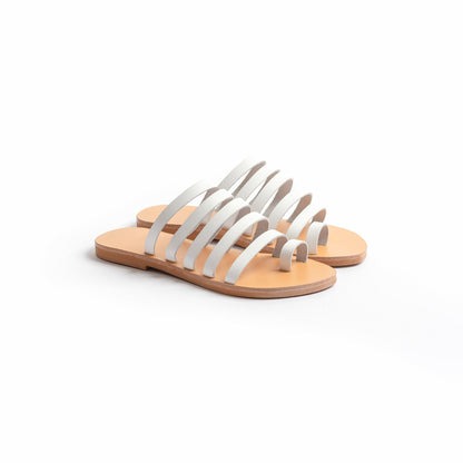 Harmonia white slide sandals against a white background. These white leather sandals are white flats for women.