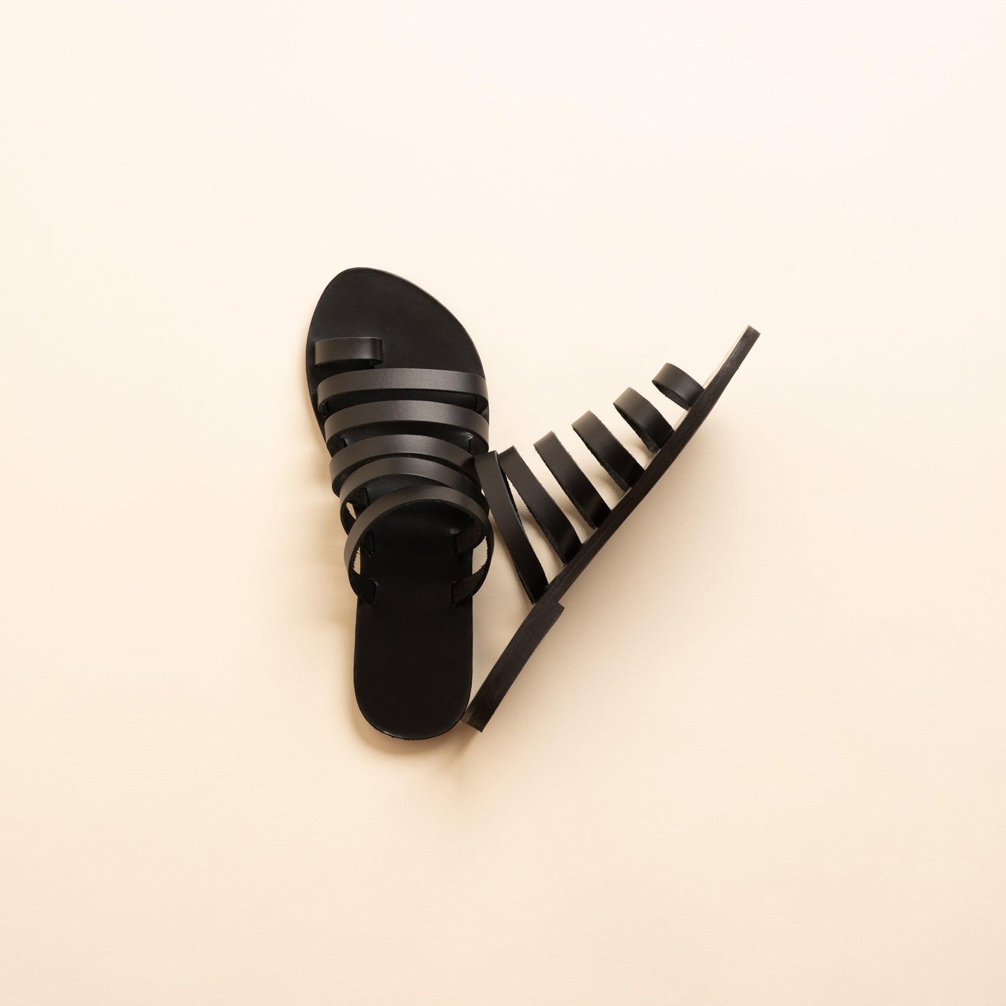 Harmonia womens leather flats in black against a beige background. These step in sandals flat are flat sandals luxury brand.