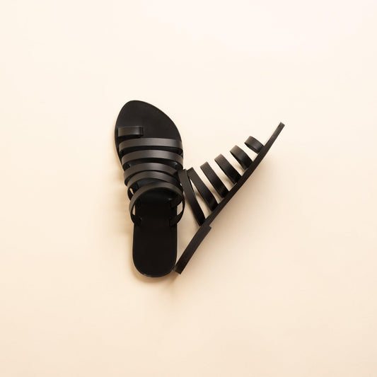 Harmonia womens leather flats in black against a beige background. These step in sandals flat are flat sandals luxury brand.