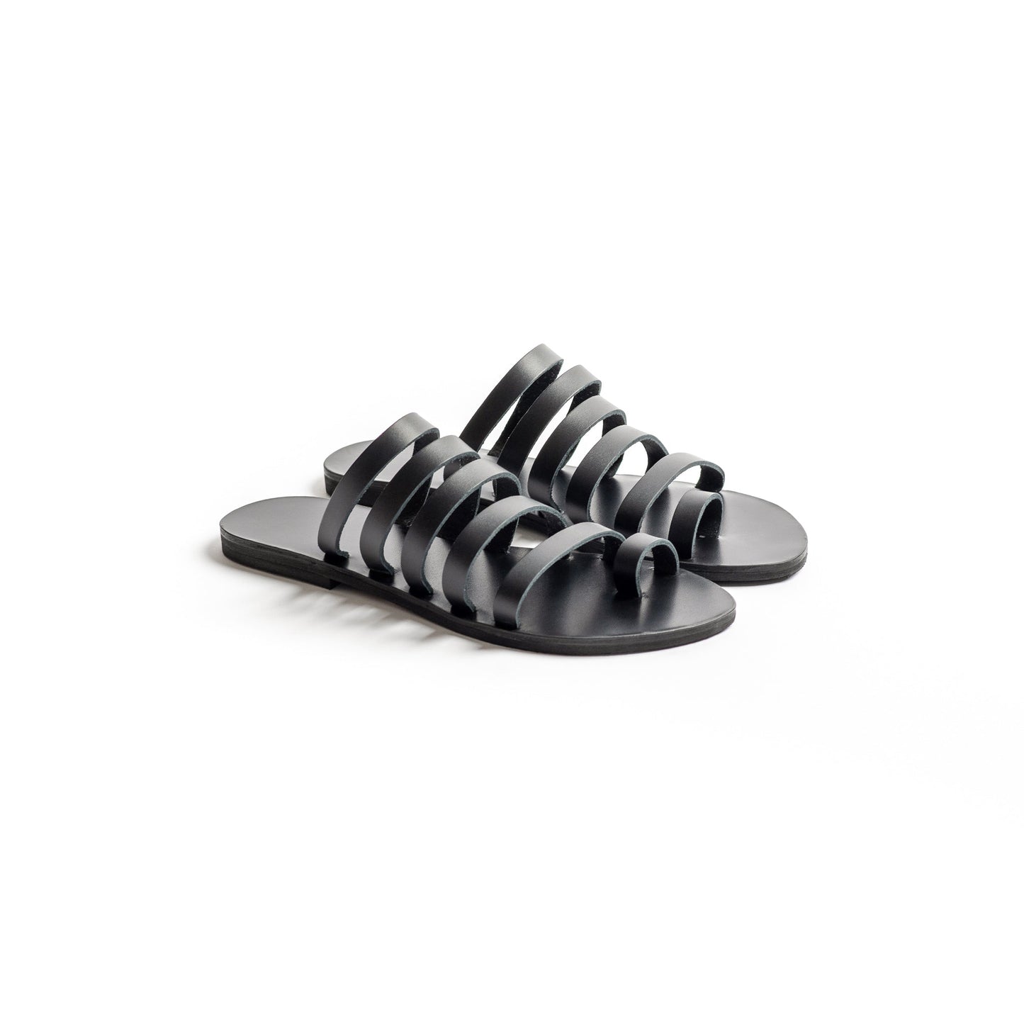 Harmonia womens leather flats in black against a white background. They are step in sandals flat.