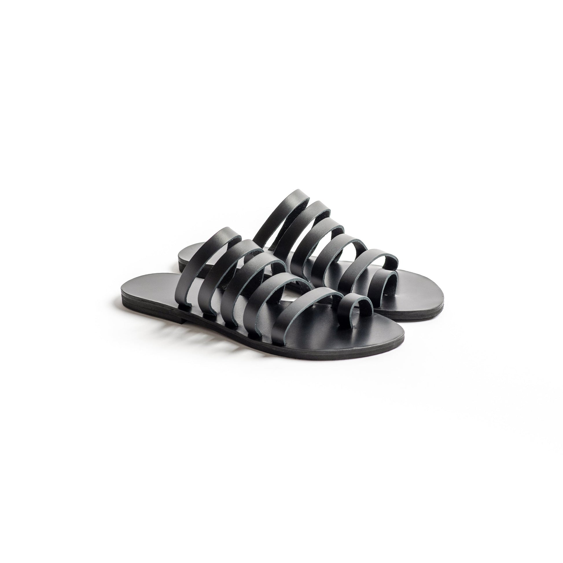 Harmonia womens leather flats in black against a white background. They are step in sandals flat.