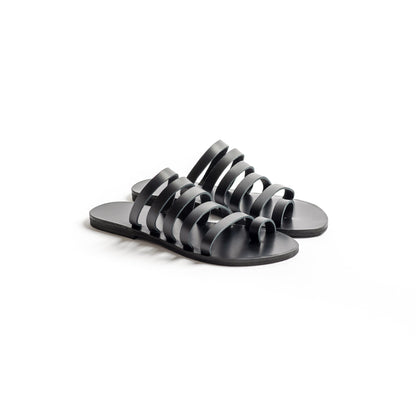 Harmonia womens leather flats in black against a white background. They are step in sandals flat.