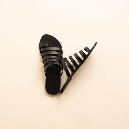 Harmonia womens leather flats in black against a beige background. These step in sandals flat are flat sandals luxury brand.
