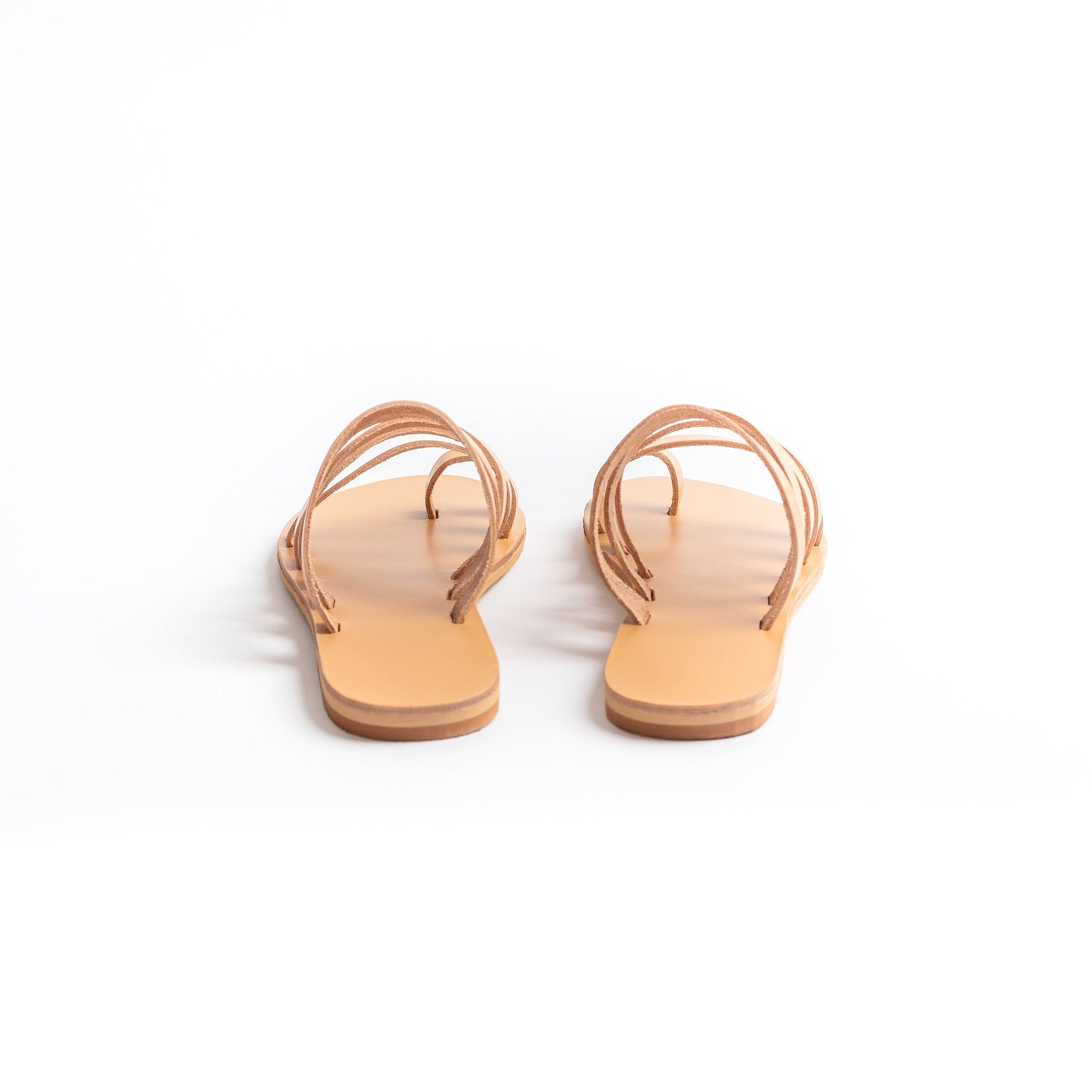 Back view of Harmonia flat sandals open toe against a white background. These are flat sandals without back strap.