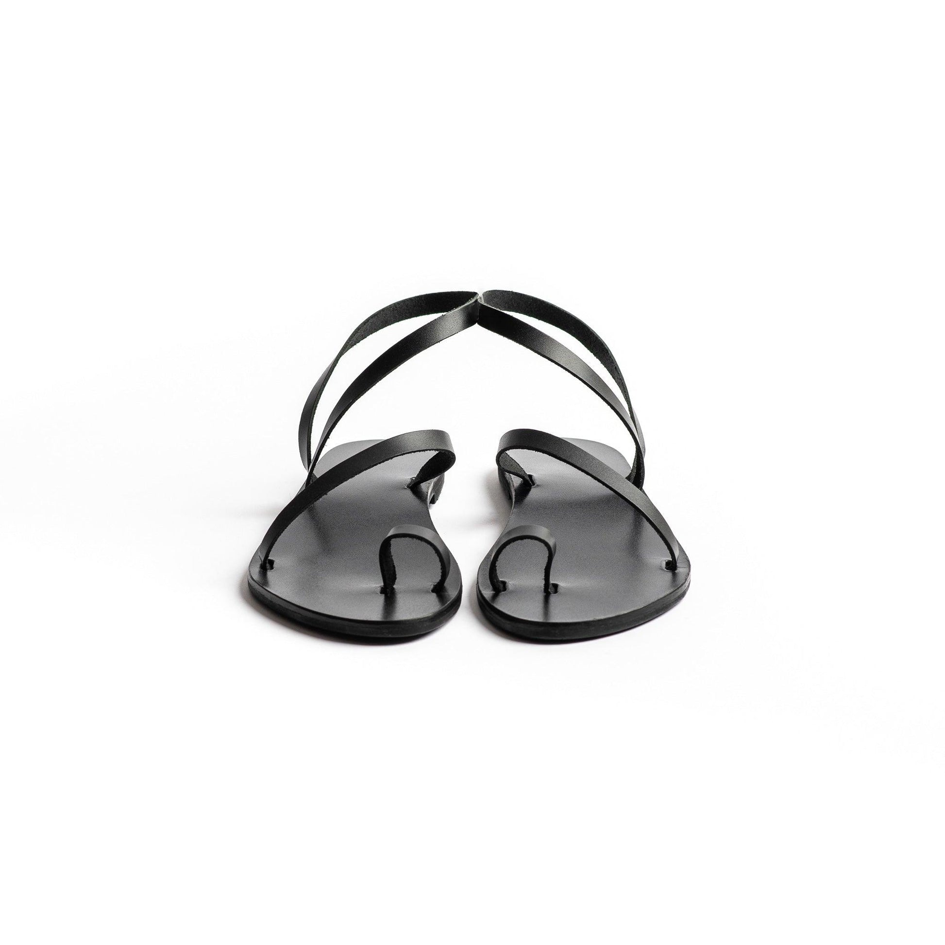 Front view of a pair of fancy black flats on a white background. These flat sandals black are the perfect flat sandals to wear with dresses.