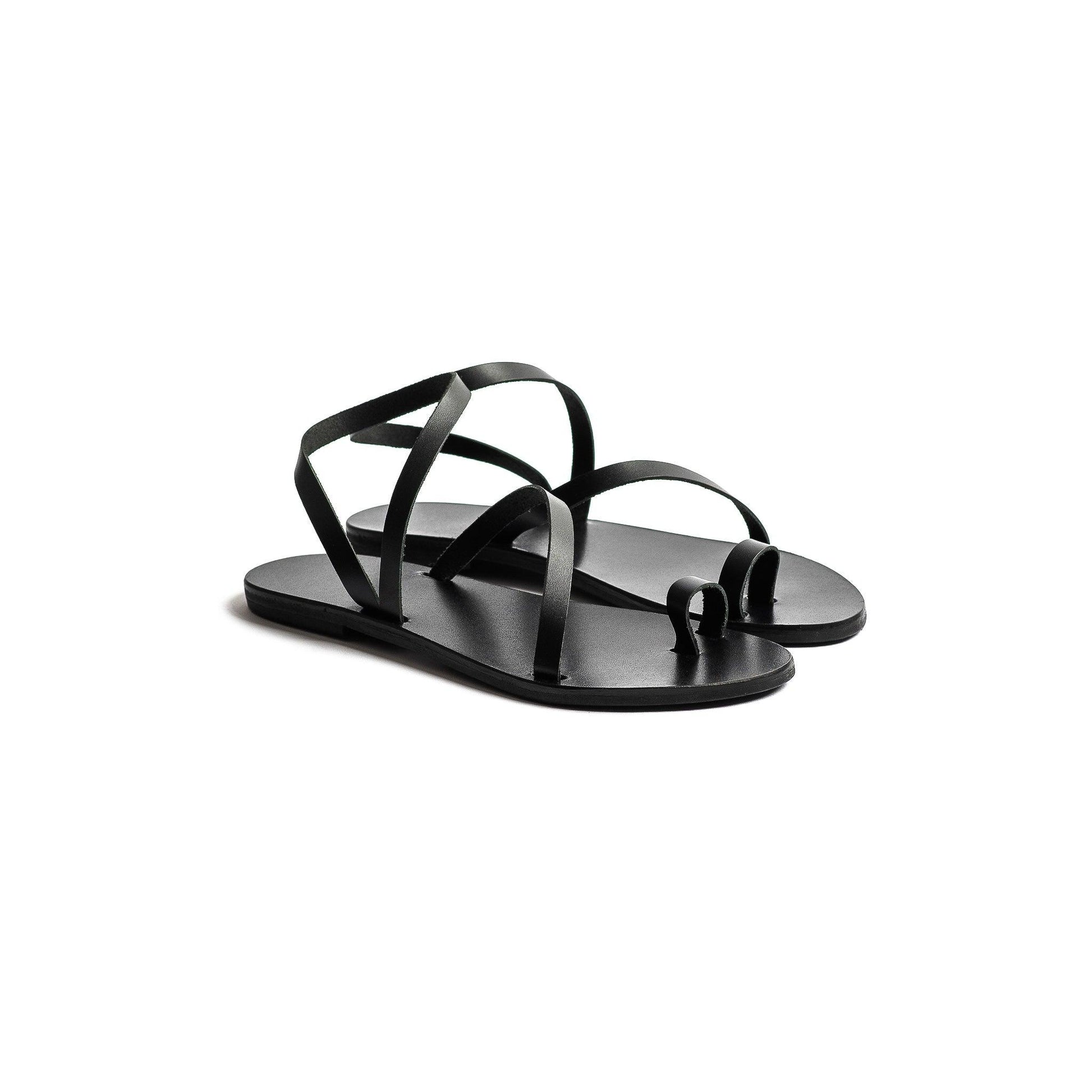 Pair of flats sandals black against a white background. They are fancy black flats.