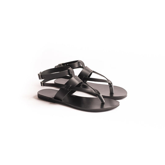 Rhea black double strap sandals featured against a white background. They are black flats for women.